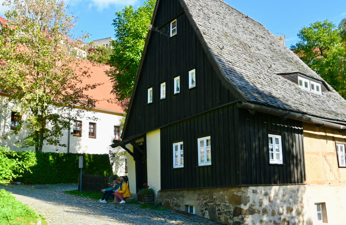 Flo, Ben und Melanie mit dem Stadtspiel vor dem Hexenhaus
