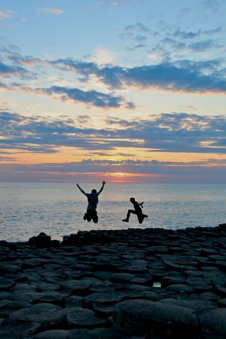 Flo und Ben springen in den Sonnenuntergang am Giants Causeway