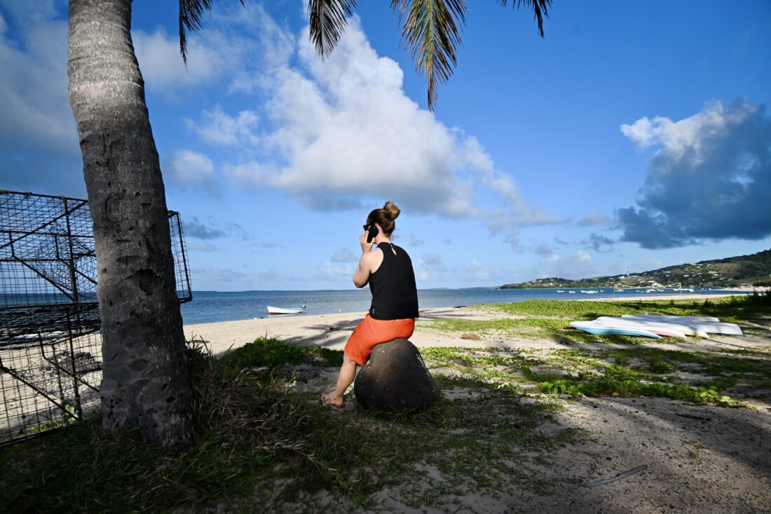 Melanie telefoniert mit eSIM am Strand vom C Mourouk Rodrigues